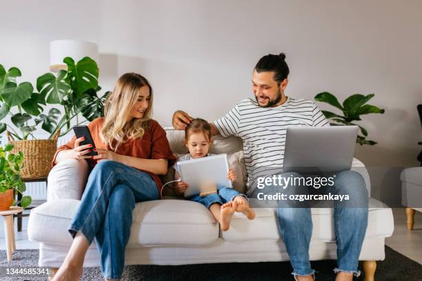 la famiglia trascorre il tempo libero a casa navigando in internet - familie laptop foto e immagini stock