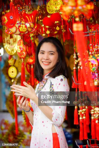 vietnamesisches mädchen kauft dekorationen artikel bereiten sie sich auf tet urlaub vor - tet stock-fotos und bilder