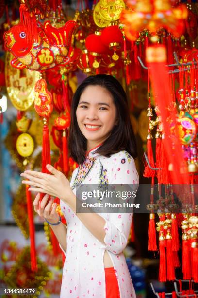 vietnamese girl buying decorations item prepare for tet holiday - tet vietnam stock pictures, royalty-free photos & images