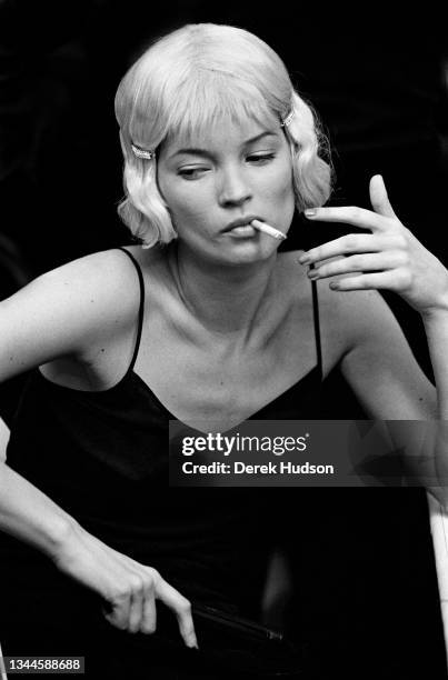 British fashion model Kate Moss smokes a cigarette at make-up prior to an appearance , Paris, France, 1998.