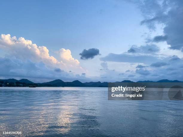 evening scenery of west lake in hangzhou, china under cumulonimbus clouds - vista de la tierra fotografías e imágenes de stock