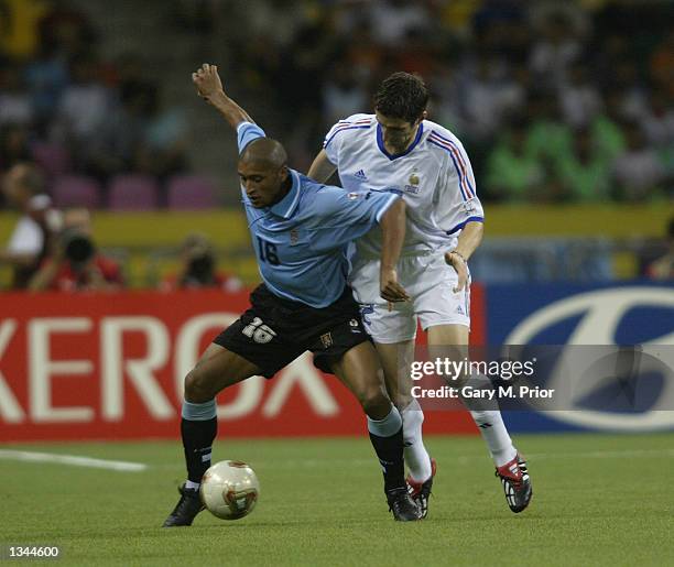 Marcelo Romero of Uruguay shields the ball from Johan Micoud of France during the FIFA World Cup Finals 2002 Group A match played at the Asiad Main...