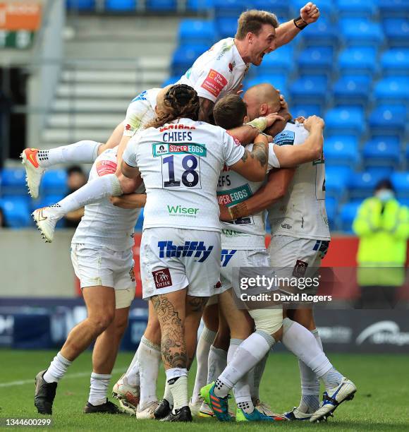 Will Witty the Exeter Chiefs lock, is mobbed by team mates after scoring their third try despite being held by Will Cliff during the Gallagher...