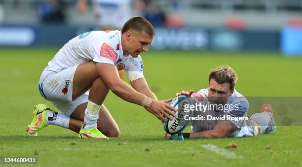 Stuart Hogg of Exeter Chiefs holds the ball as team mate Henry Slade prepares to take a conversion of his own second try during the Gallagher...