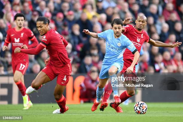 Bernardo Silva of Manchester City breaks away from Fabinho and Virgil van Dijk of Liverpool during the Premier League match between Liverpool and...