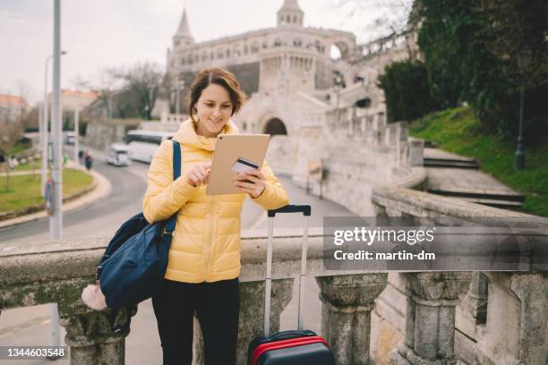 woman traveling in europe and using credit card for hotel reservation - hungary hotel stock pictures, royalty-free photos & images