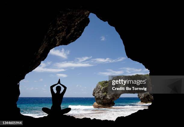 young woman doing yoga in a cave - niue stock pictures, royalty-free photos & images