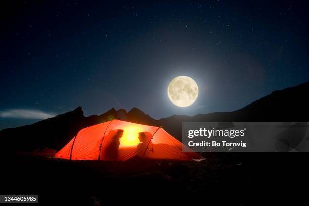 couple in tent under full moon - couple camping stock pictures, royalty-free photos & images