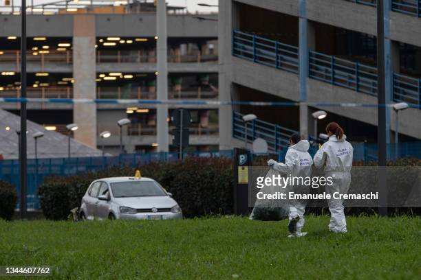 Forensic officers look for evidence after a small private plane, which took off from the nearby Milan Linate airport heading to Sardinia, crashed...