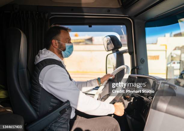 chauffeur de camion portant un masque facial à l’intérieur d’un camion - camion citerne photos et images de collection