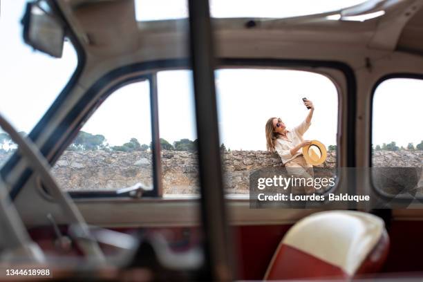 woman taking selfie near old car - open hair selfie stock pictures, royalty-free photos & images