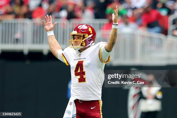 Quarterback Taylor Heinicke of the Washington Football Team raises his arms to signal a touchdown in the second quarter against the Atlanta Falcons...