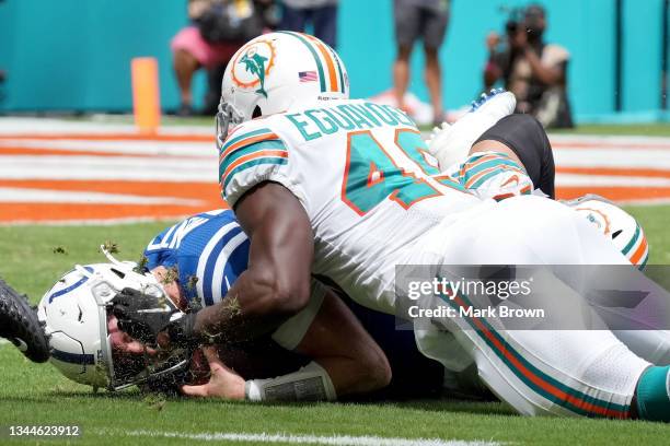 Carson Wentz of the Indianapolis Colts is sacked by Sam Eguavoen of the Miami Dolphins during the second quarter at Hard Rock Stadium on October 03,...