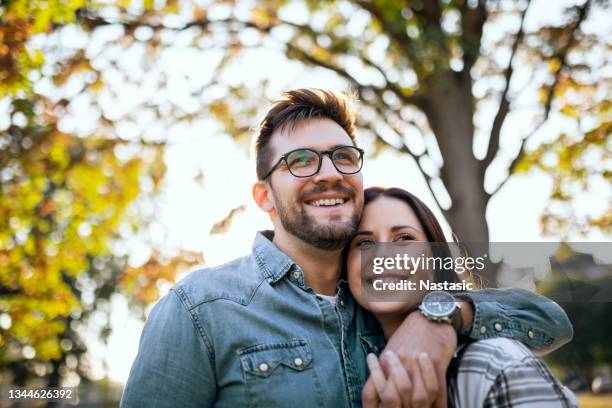 giovane coppia e giornata di sole autunnale - man hugging woman foto e immagini stock