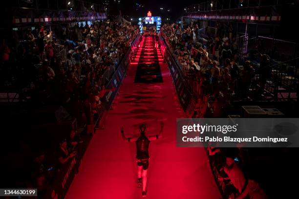 An athlete celebrates crossing the finish line of Ironman Barcelona on October 03, 2021 in Barcelona, Spain.