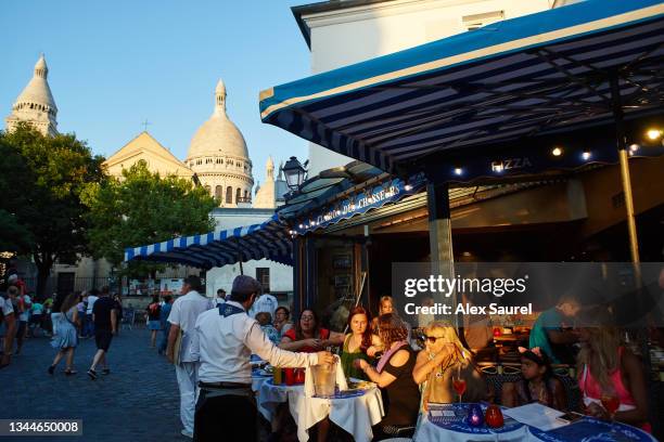 tourists sat at the terrace of a restaurent in montmartre, paris, france - church color light paris stockfoto's en -beelden