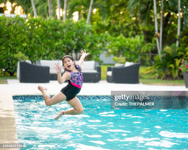 seven years old girl jumping in swimming pool - young girl jumping into swimming pool stock pictures, royalty-free photos & images