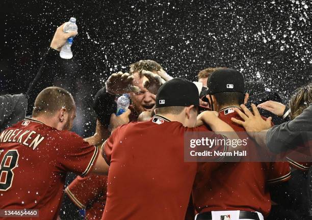 Josh VanMeter of the Arizona Diamondbacks celebrates with teammates after hitting a walk-off home run against the Colorado Rockies during the ninth...