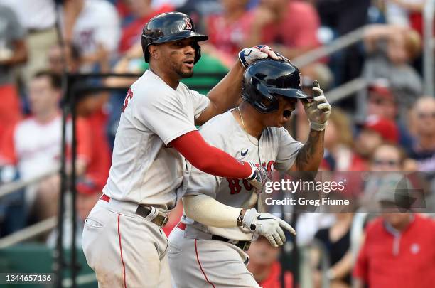 Xander Bogaerts and Rafael Devers of the Boston Red Sox celebrate after scoring in the seventh inning against the Washington Nationals at Nationals...