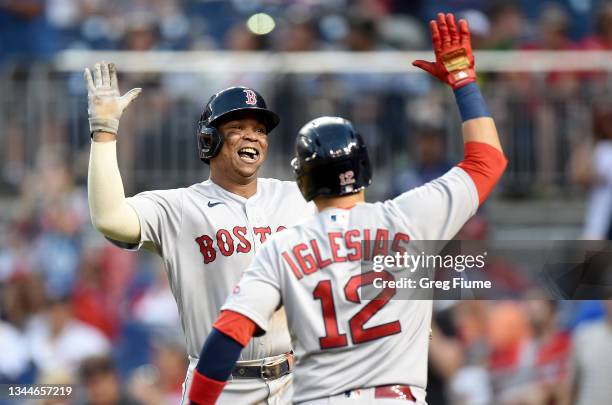 Rafael Devers of the Boston Red Sox celebrates with Jose Iglesias after hitting the game winning two-run home run in the ninth inning against the...