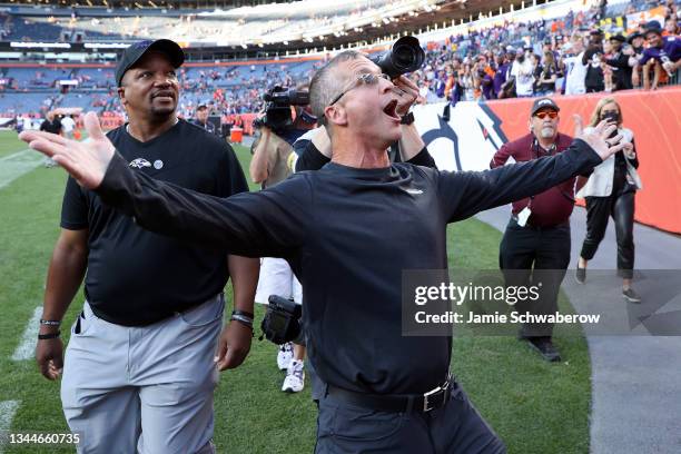 Head coach John Harbaugh of the Baltimore Ravens acknowledges Ravens fans in the stands as he walks off the field after their 23-7 win against the...