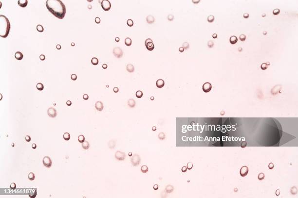 texture of pink cosmetic tonic for face care with air bubbles. flat lay style. macro - oil macro stock pictures, royalty-free photos & images