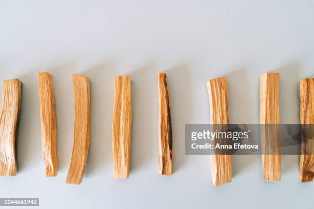 many palo santo sticks arranged in a row on gray background. set for aromatherapy and rituals. flat lay style. close-up - wooden stick stock pictures, royalty-free photos & images