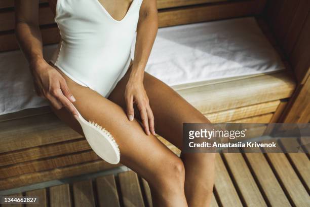 unrecognizable multiracial woman making anti cellulite or lymphatic thigh massage at sauna, closeup. - natural organic thermo cosmetics foto e immagini stock