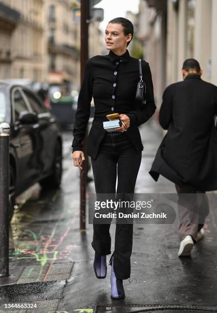Model Cara Taylor is seen wearing a black shirt, black pants and purple boots outside the Lanvin show during Paris Fashion Week S/S 2022 on October...