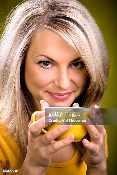 young woman holding a teacup - bleek gezicht stockfoto's en -beelden