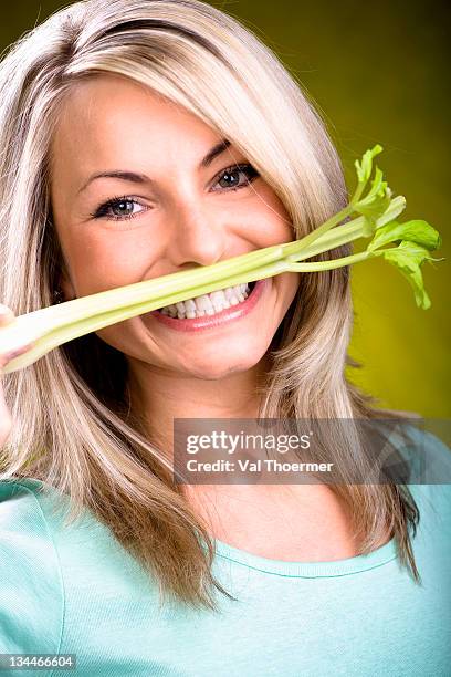 young woman with celery - bleek gezicht stockfoto's en -beelden