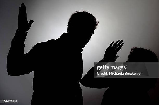 man beating woman, silhouette - silhouette contre jour fotografías e imágenes de stock