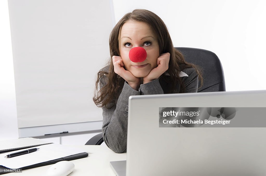 Business woman with a red clown nose