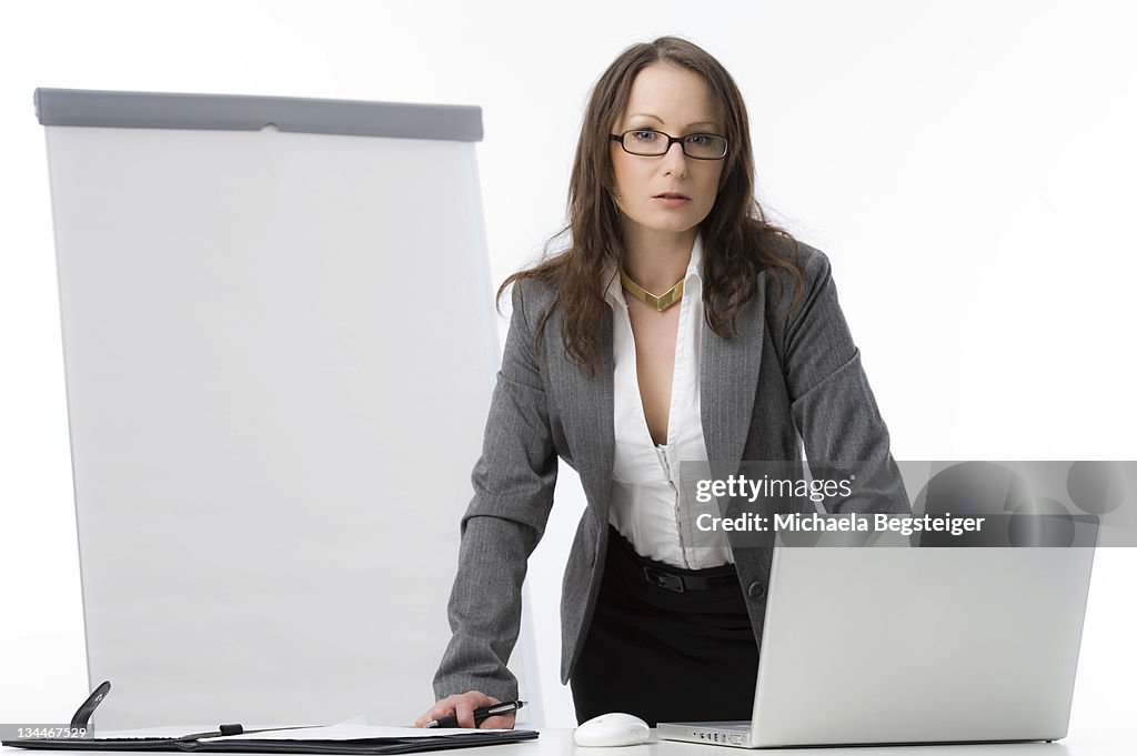 Businesswoman with a laptop and a flipchart