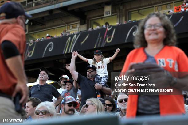 Fans celebrate in the top of the ninth before the San Francisco Giants defeated the San Diego Padres 11-4 to win the National League West at Oracle...