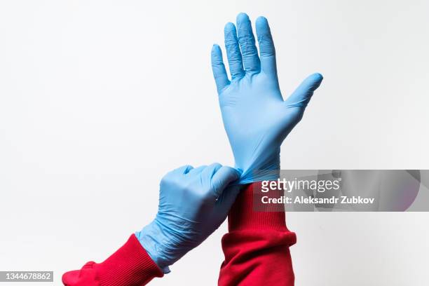 a nurse, doctor, medical worker or a woman wears protective latex rubber gloves. the concept of healthcare and medicine. prevention of the spread of viruses, infections, bacteria and coronavirus. - medical glove stock pictures, royalty-free photos & images