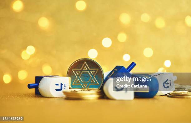 hanukkah background with dreidel and gold coins on gold background - chanoeka stockfoto's en -beelden