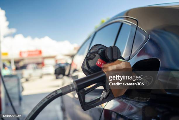 close up refueling fuel oil gasoline for eco car at gas station - ガソリンスタンド ストックフォトと画像