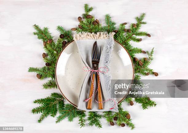 christmas table setting with plate, fork, knife and branches of fir with pine cone - conifer cone stock pictures, royalty-free photos & images