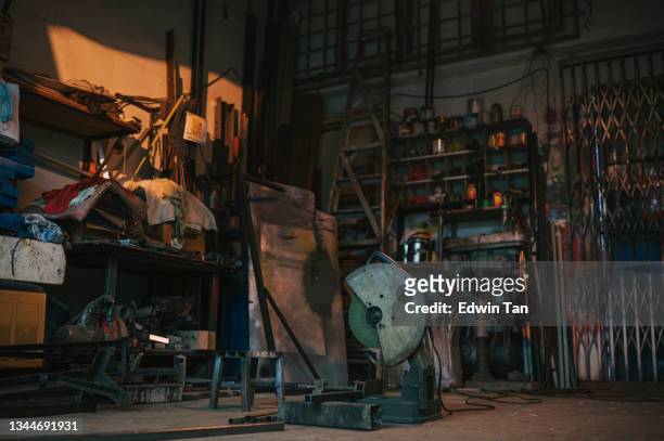 rustic old messy workshop without people illuminated by sunset lighting - smederij stockfoto's en -beelden