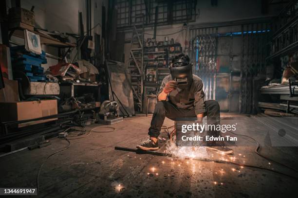 asian malay welder welding working in the workshop with welding torch repairing - blacksmith sparks stock pictures, royalty-free photos & images