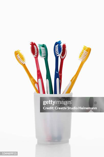 toothbrushes in a toothbrush tumbler - colourful studio shots stock-fotos und bilder