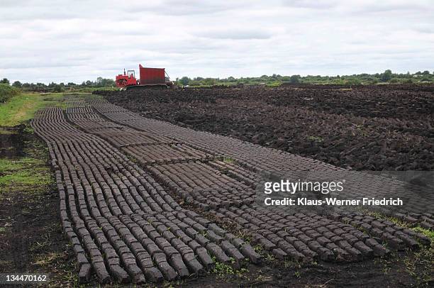 machine for the pressing of black peat and rows of peat used for fuel in private homes, birr, leinster, republic of ireland, europe - peat stock pictures, royalty-free photos & images