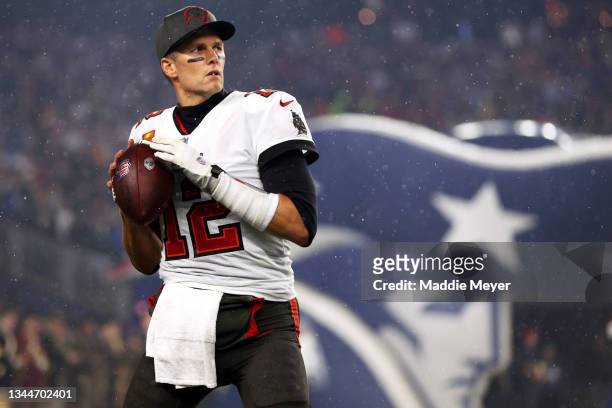 Tom Brady of the Tampa Bay Buccaneers warms up in front of the New England Patriots tunnel before the game between the Buccaneers and the Patriots at...