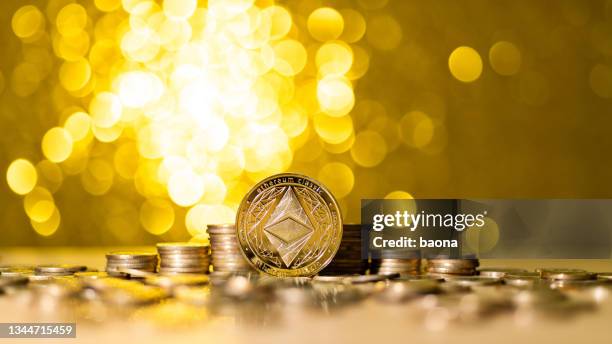 heap of ethereum on shiny golden background - ethereum stockfoto's en -beelden