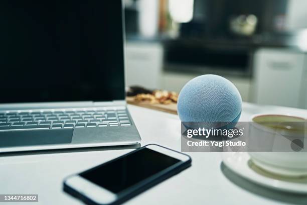 using a smart speaker in kitchen counter - smart speaker stock pictures, royalty-free photos & images