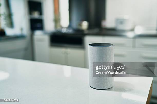 using a smart speaker in kitchen counter - premier plan net photos et images de collection