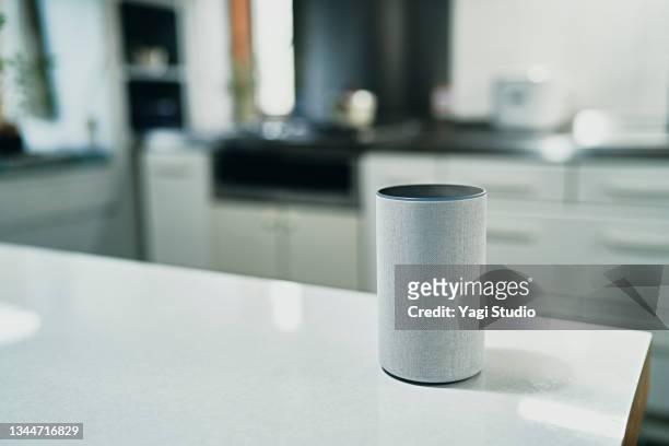 using a smart speaker in kitchen counter - ai speaker stock pictures, royalty-free photos & images