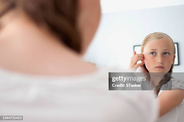 girl looking in mirror - girl in mirror stockfoto's en -beelden