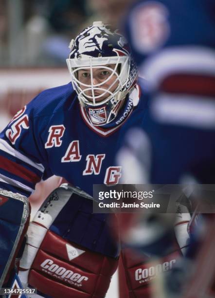 Mike Richter Goaltender for the New York Rangers looks out from behind his face mask as he tends goal during the NHL Western Conference Pacific...